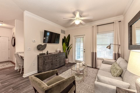 a living room with furniture and a ceiling fan
