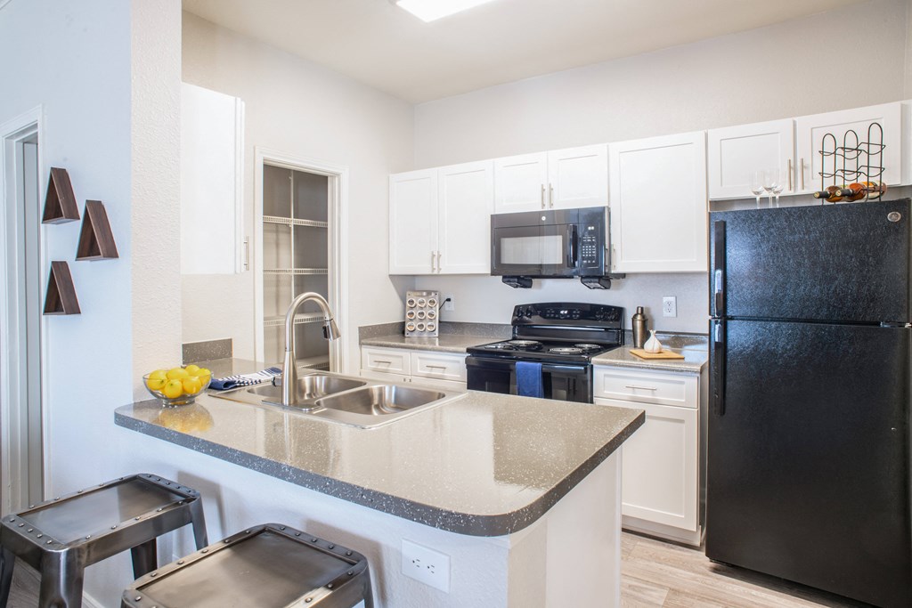 a kitchen with white cabinets and black appliances at Lincoln at Wolfchase, Cordova