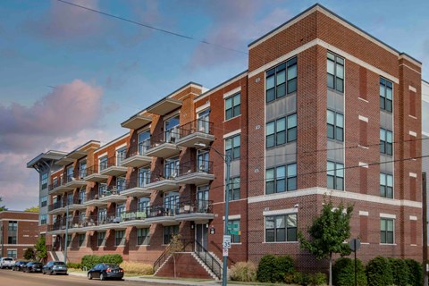 A large red brick building with a balcony on the second floor.