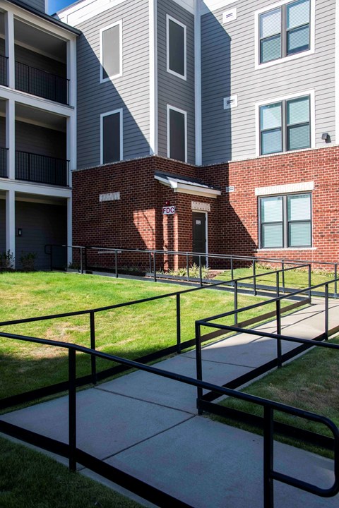 A brick building with a black railing in front of it.