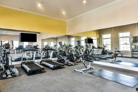 a large fitness room with cardio equipment and flat screen televisions at Meridian Park in Collierville, TN 38017