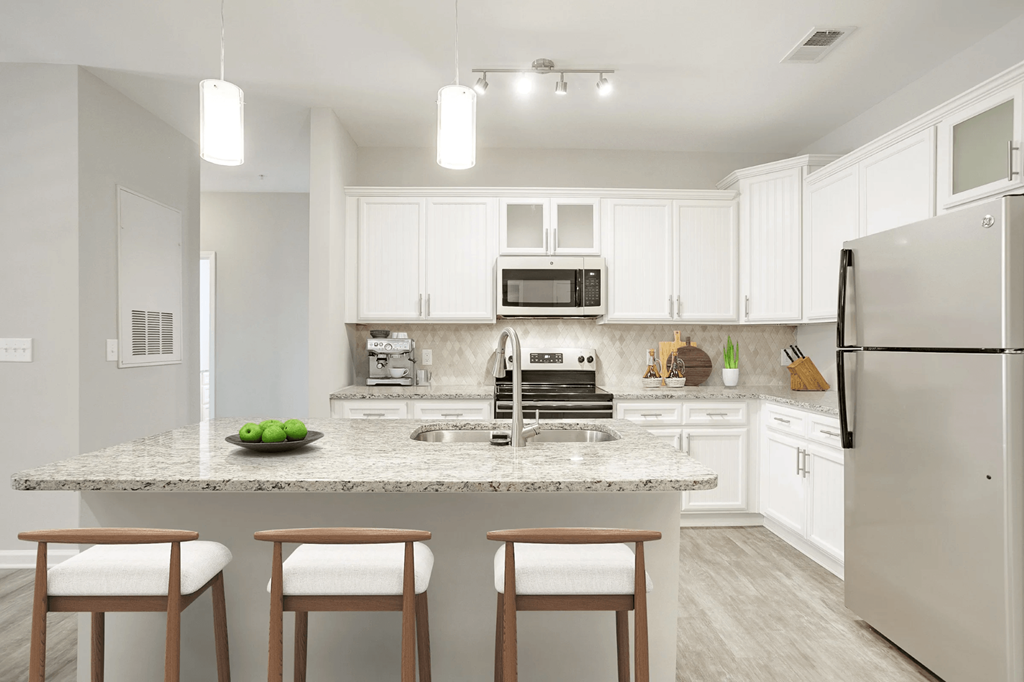 A kitchen with a granite countertop and white cabinets at Henley at Mirror Lake Apartments, Villa Rica, GA, 30180