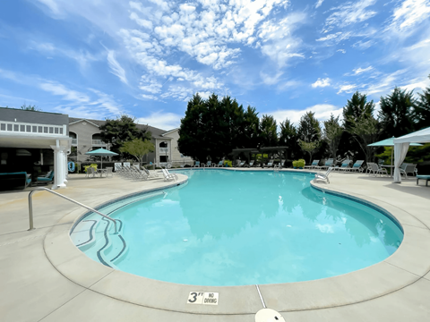 A large swimming pool with a white fence around it.