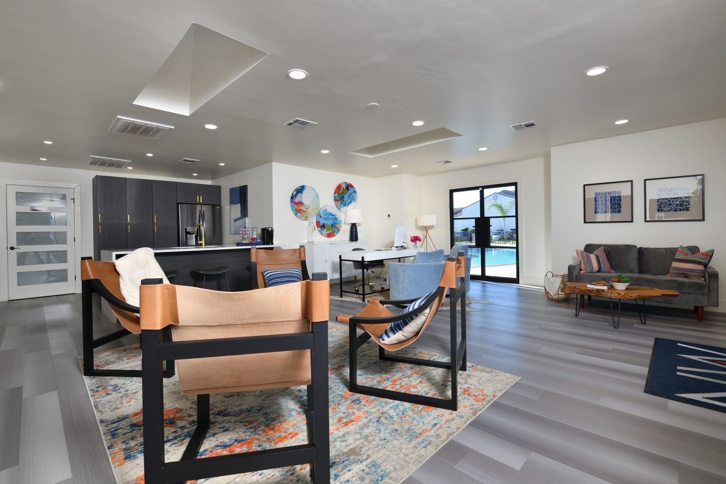 A modern living room with a grey sofa and a wooden chair.