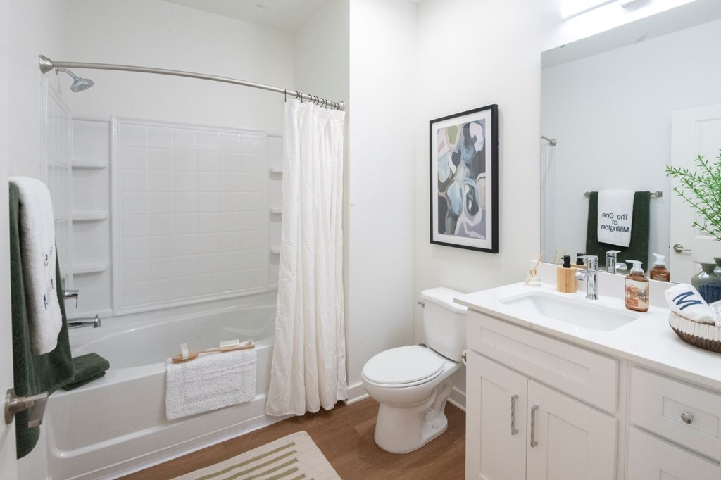 A white bathroom with a toilet, sink, and bathtub.