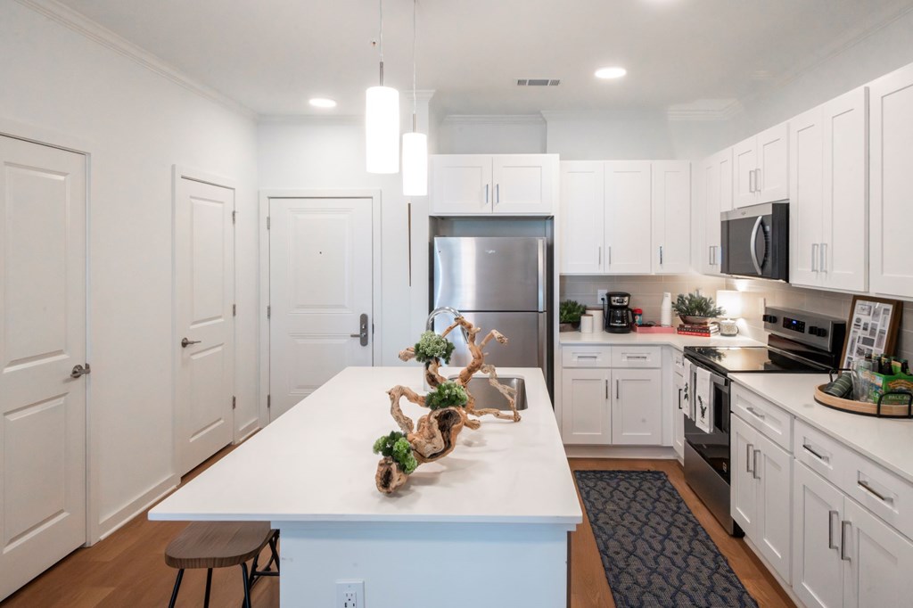 A kitchen with white cabinets and a blue island.
