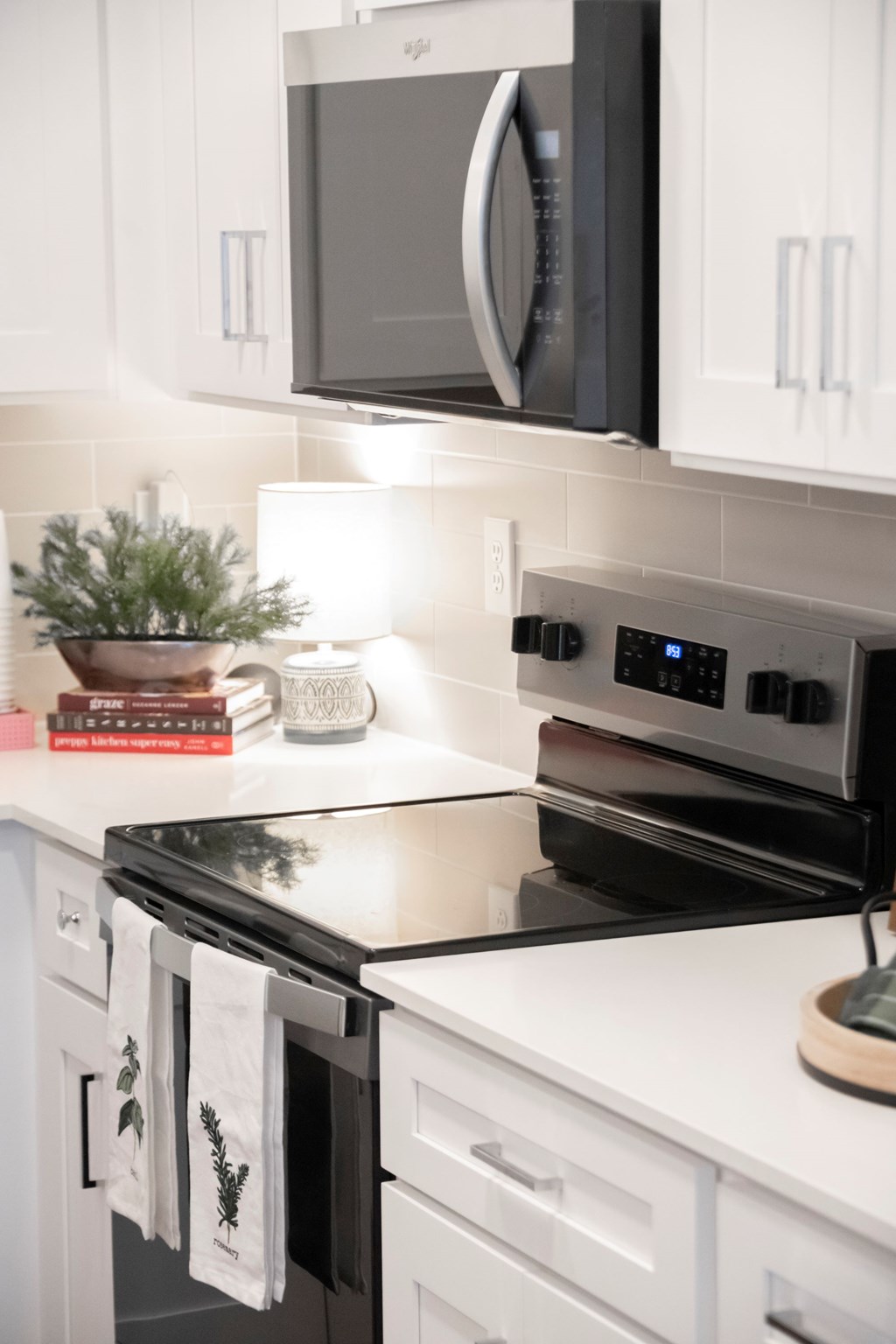 A modern kitchen with a black stove top oven and white cabinets.