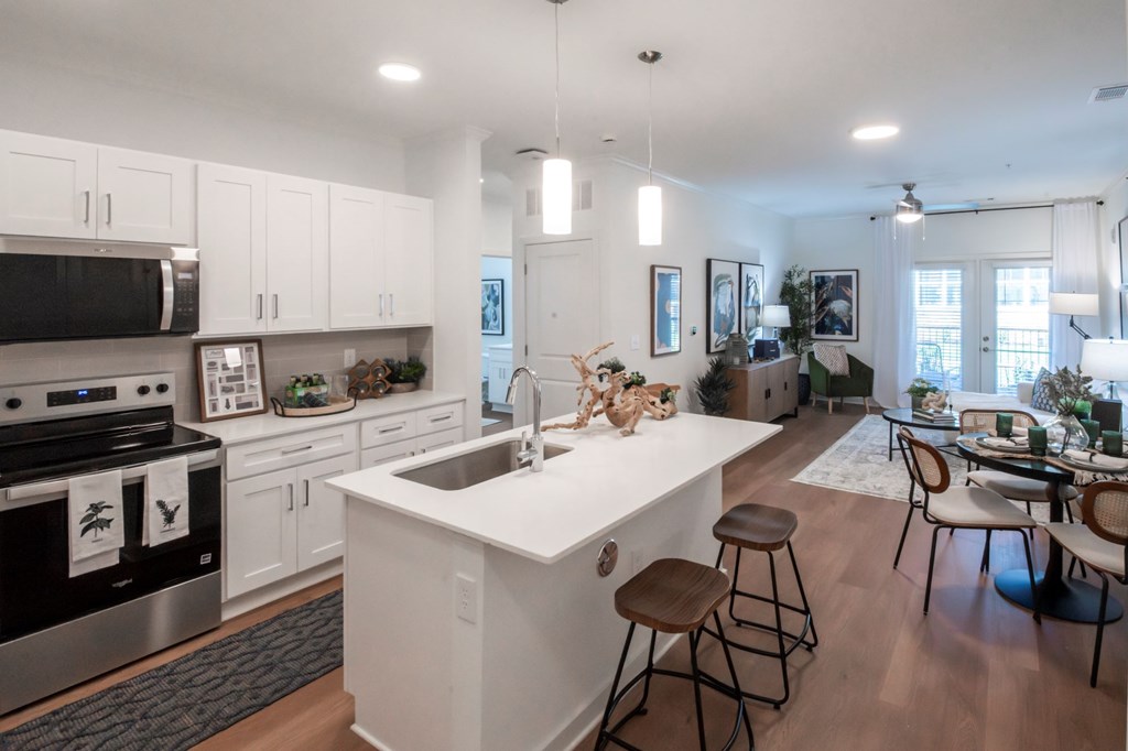 A modern kitchen with white cabinets and a large island.