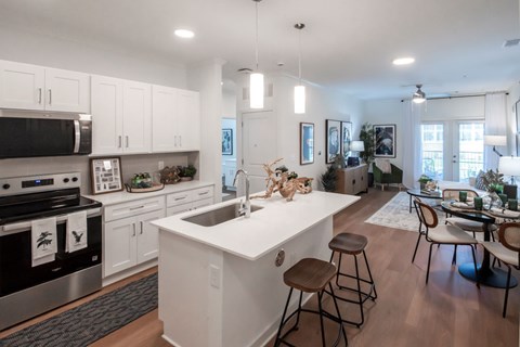 A modern kitchen with white cabinets and a large island.