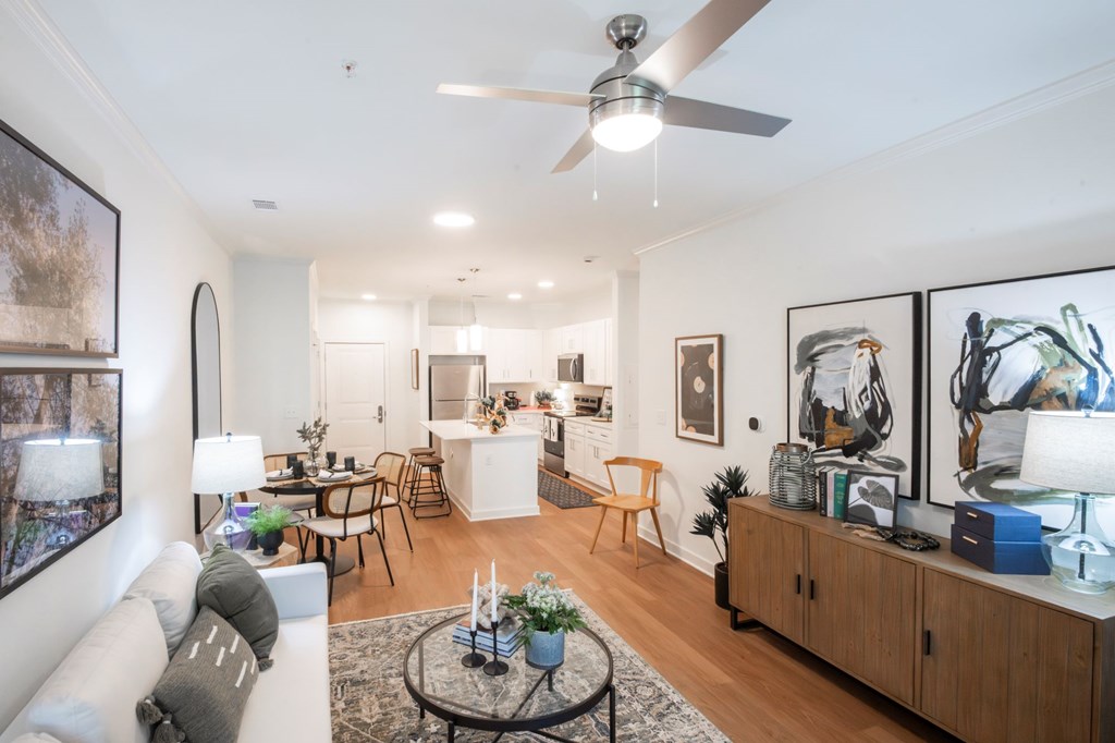 A living room with a white couch, a coffee table, and a ceiling fan.