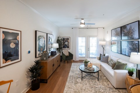 A living room with a white couch, a coffee table, and a painting on the wall.