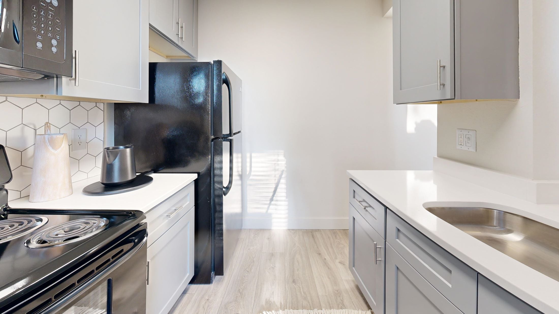 A modern kitchen with a black refrigerator and stove.