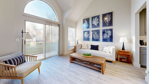 A living room with a sofa, a table, and a chair.