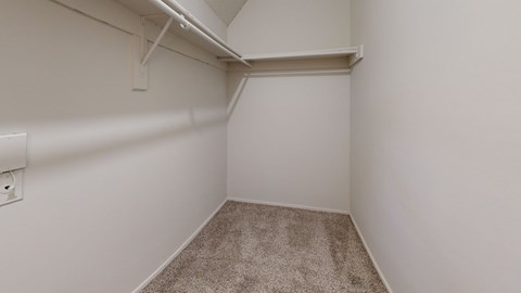 A small, empty room with a carpeted floor and white walls.