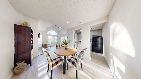 A dining room with a round table and chairs.