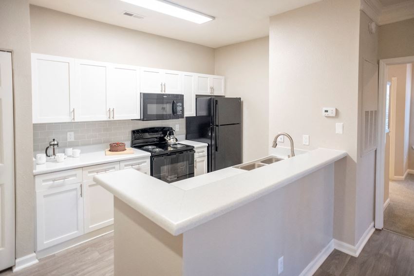 White Cabinetry and Black Appliances Kitchen with Breakfast Barat Polos at Hudson Corners Apartments, South Carolina 29650 - Photo Gallery 1