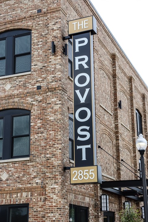 The Provost building is made of brick and has a black and white sign on it.