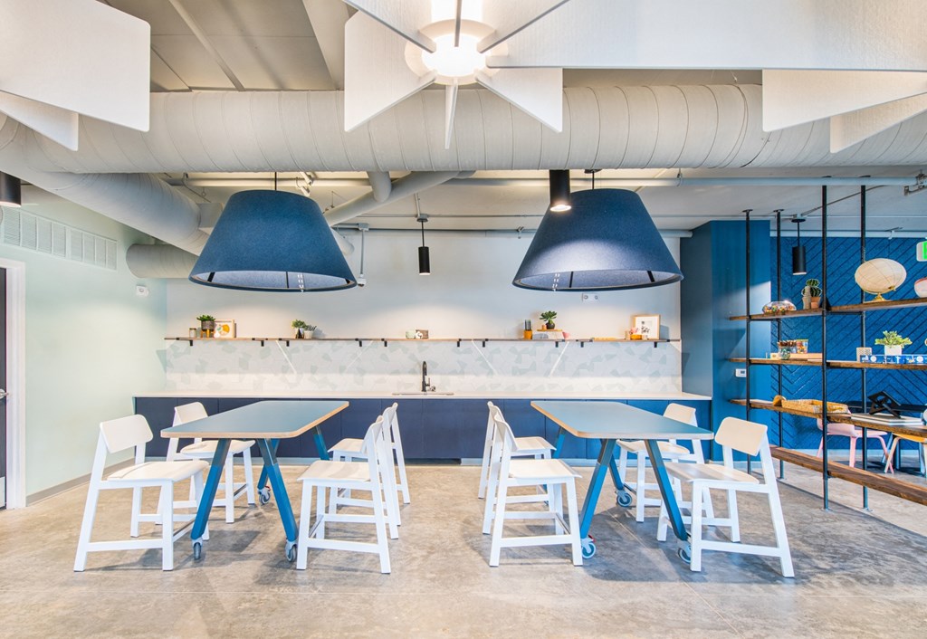a dining room with blue chairs and tables and a bar