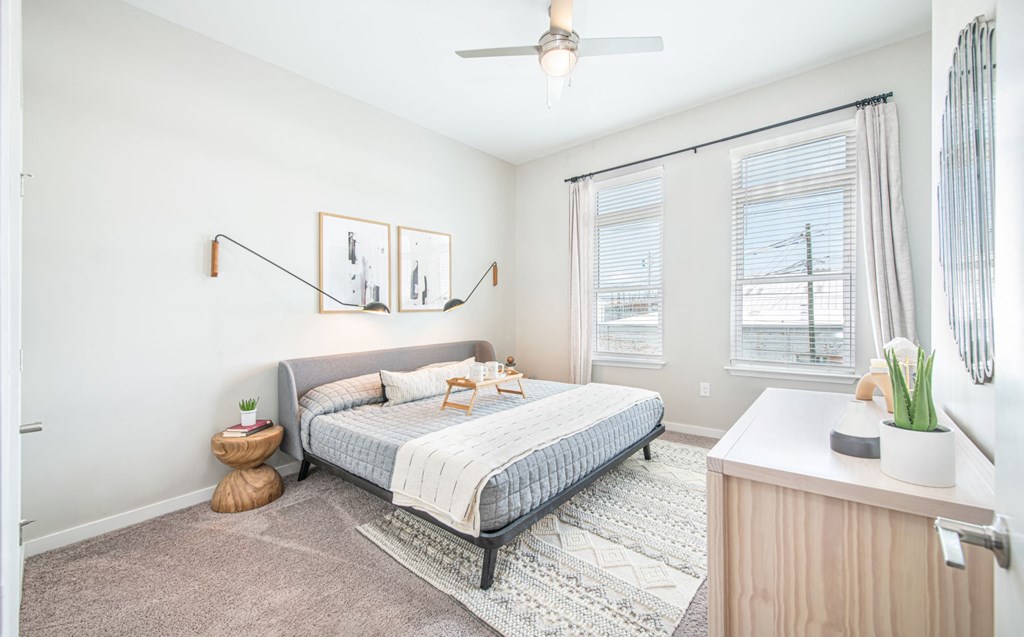 a bedroom with a bed and two windows