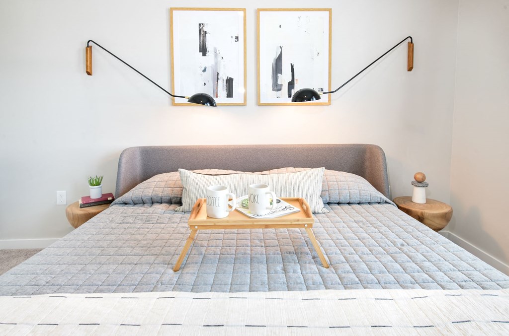 a bedroom with a bed and two pictures on the wall