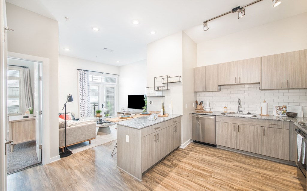 a kitchen and living room with wood floors and white walls