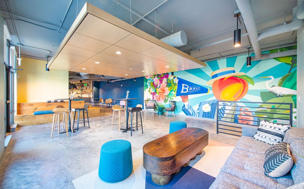 a lobby with a colorful wall and a seating area with stools