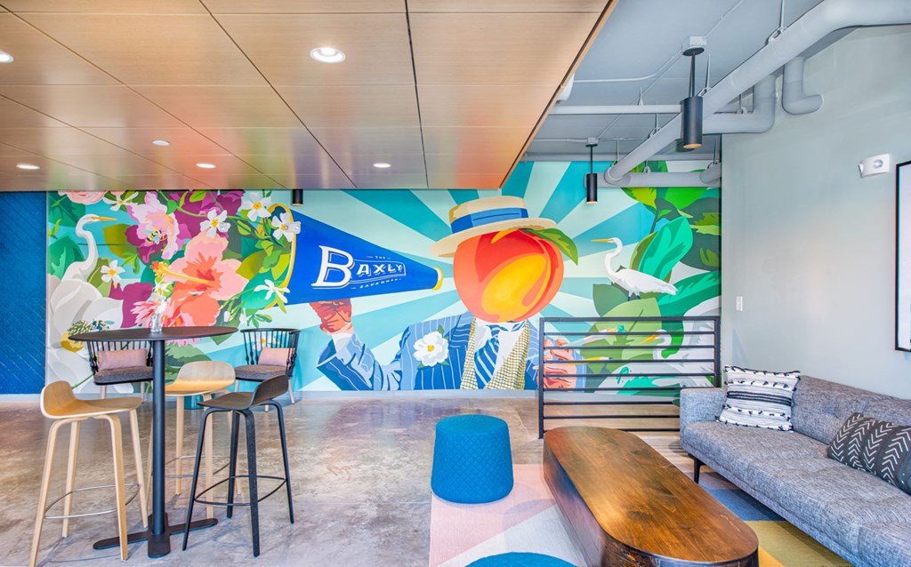 a lobby with a colorful mural on the wall and a couch and tables