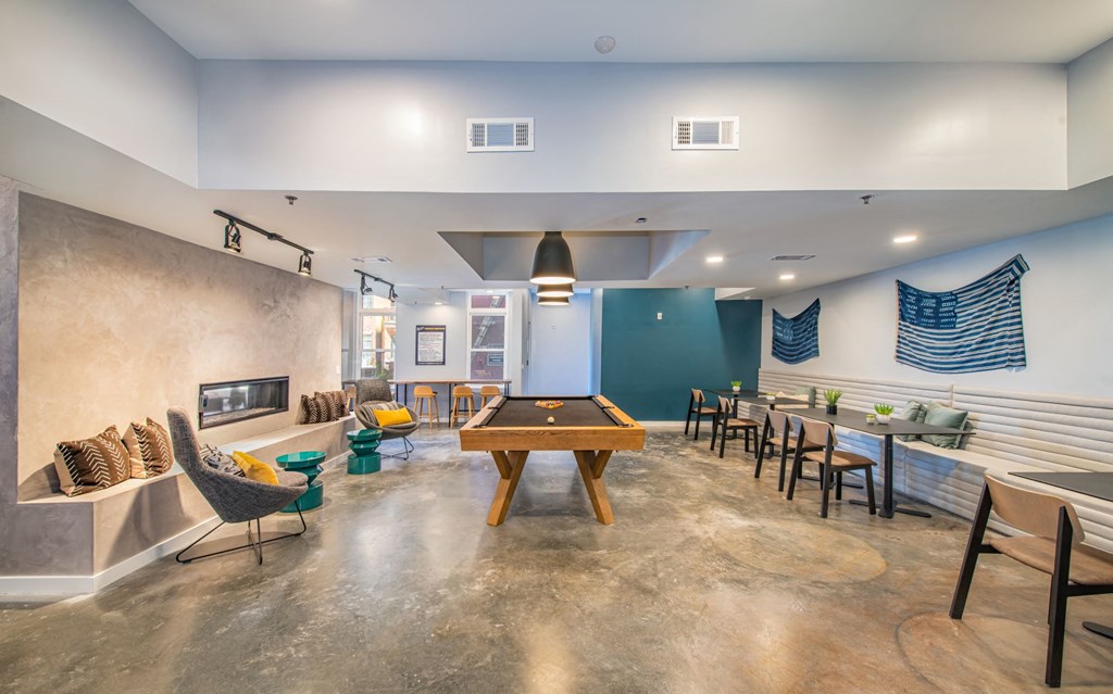 a game room with a pool table and tables and chairs