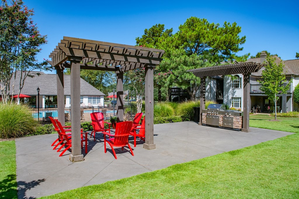a patio with red chairs and a pergola at The Addison at Collierville, Collierville, TN