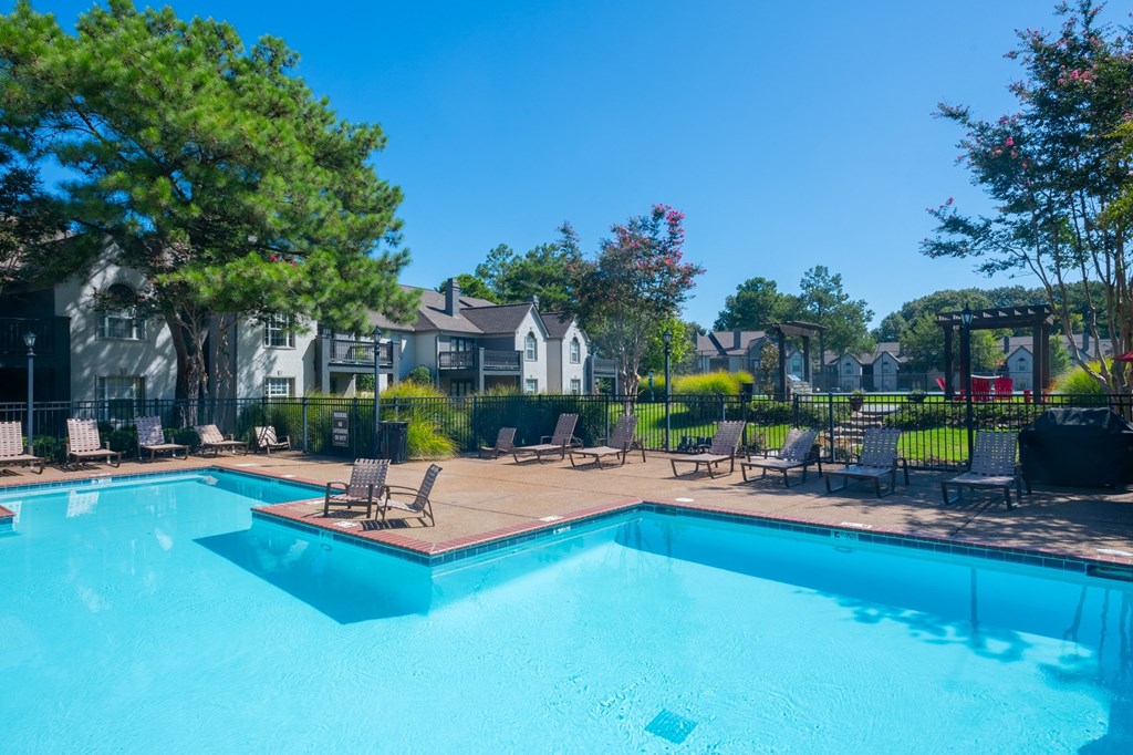 a swimming pool with chairs and trees and houses in the background at The Addison at Collierville, Collierville, TN, 38017