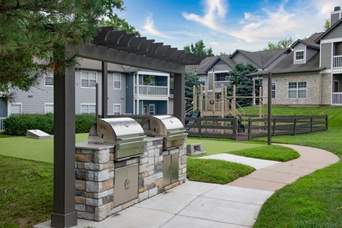 A stone wall with a metal mailbox in front of apartment buildings.