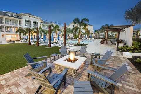 a patio with a firepit and chairs and a pool in the background at Livano Springdale, Louisville, KY