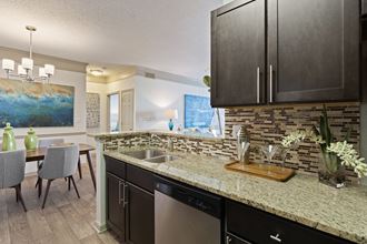 Kitchen with Granite Countertops and Backsplash located at St. Andrews Apartments in Johns Creek, GA 30022