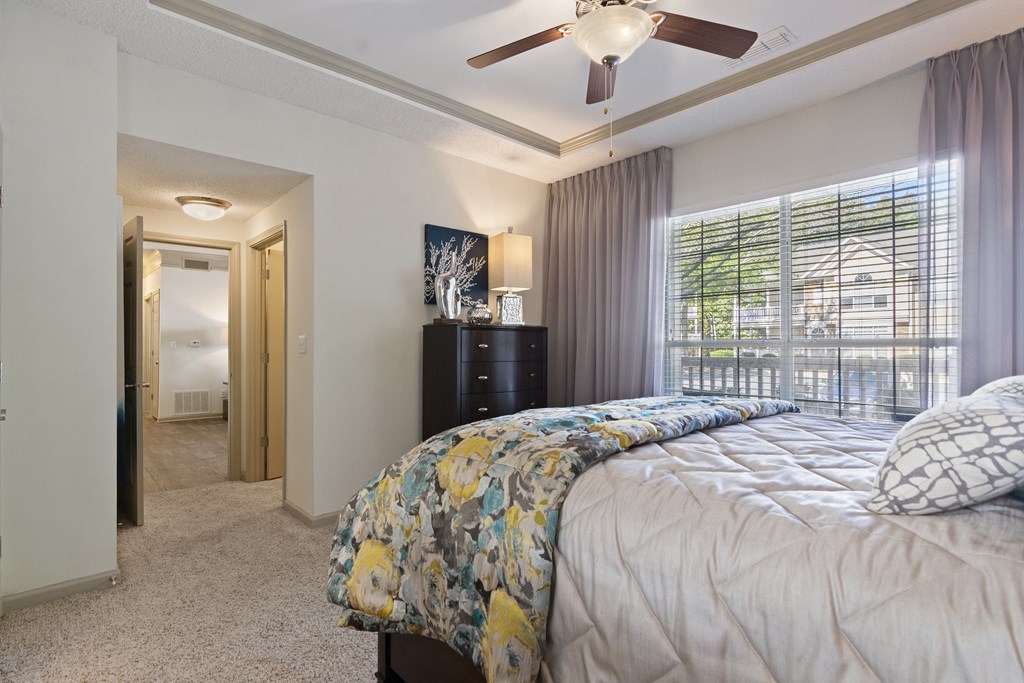 Bedroom with cozy bed in Model Apartment located at St. Andrews Apartments in Johns Creek, GA 30022