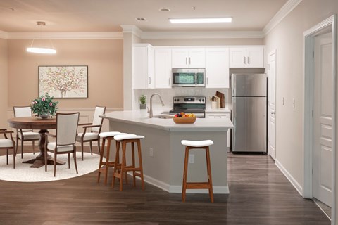 A kitchen with a table and chairs and a fridge.