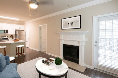 A living room with a fireplace and a painting on the wall.