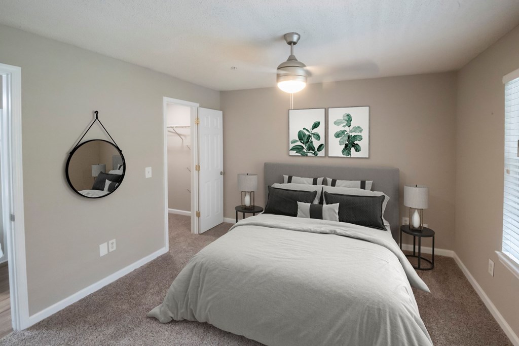 A bedroom with a large bed and a mirror on the wall.
