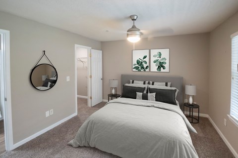 A bedroom with a large bed and a mirror on the wall.