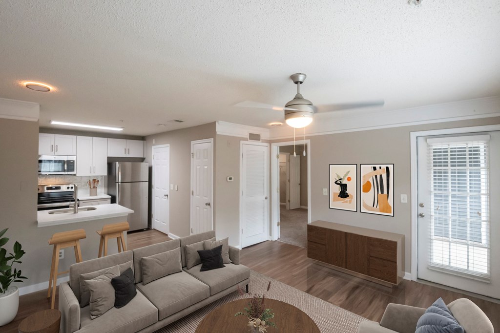 A living room with a grey couch and a ceiling fan.