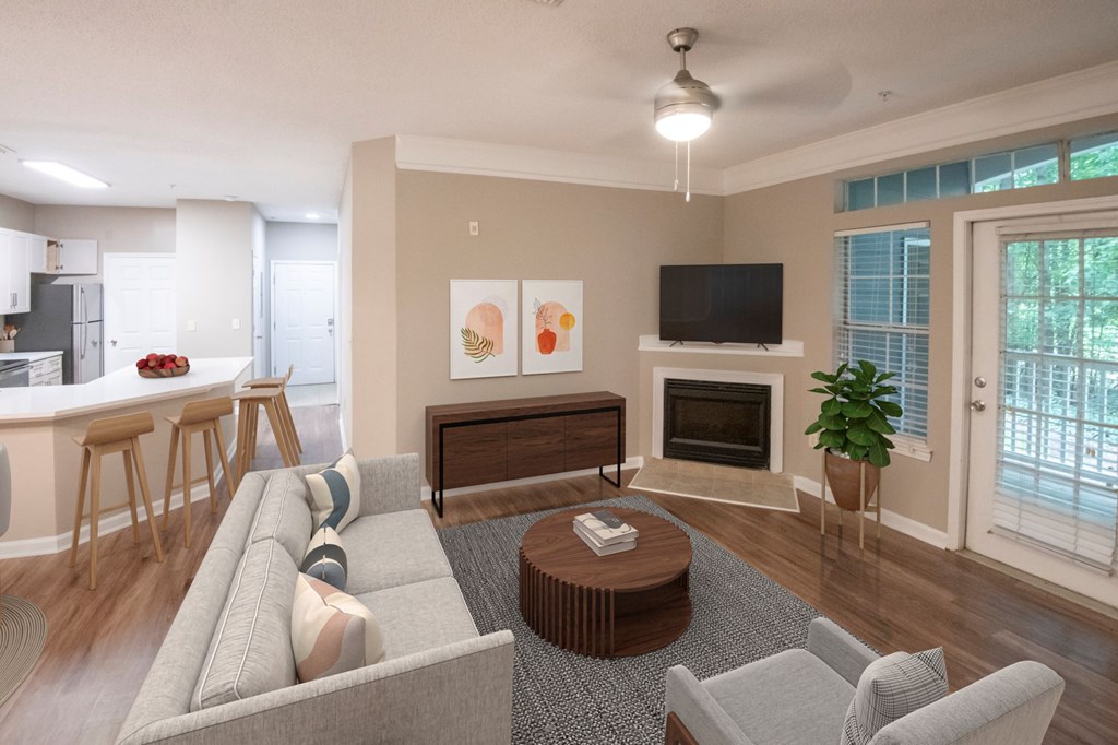 A living room with a grey couch, a coffee table, a television, and a fireplace.