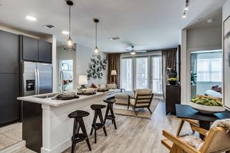 Model kitchen and den at Station at Old Town Apartments in Lewisville, TX 75075 - Photo Gallery 2