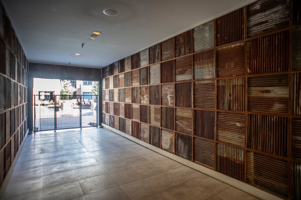 a wall of wooden panels in a lobby with a glass door
