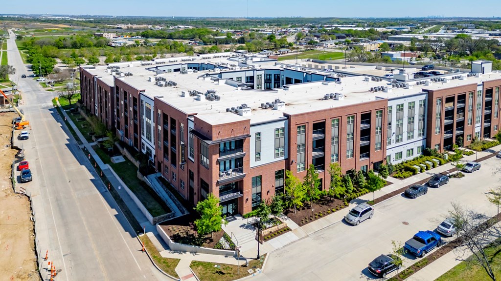 an aerial view of a building with cars parked in front of it