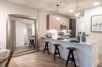 a kitchen with a bar and stools in a house at Station at Old Town, Lewisville, Texas