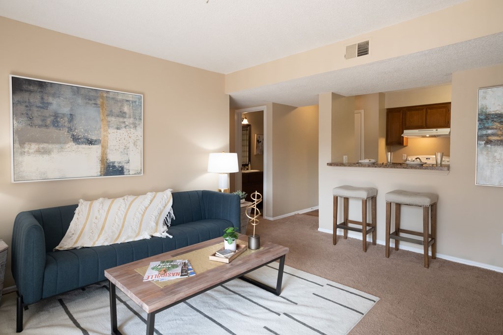 A living room with a blue couch and a coffee table.