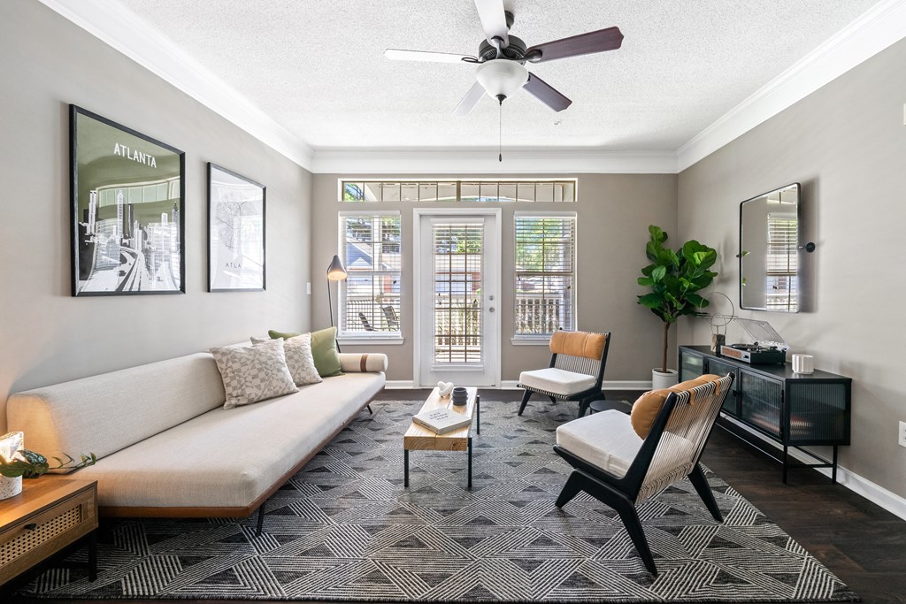 Spacious living room with patio door and ceiling fan located at Sugarloaf Crossings Apartments in Lawrenceville, GA 30046