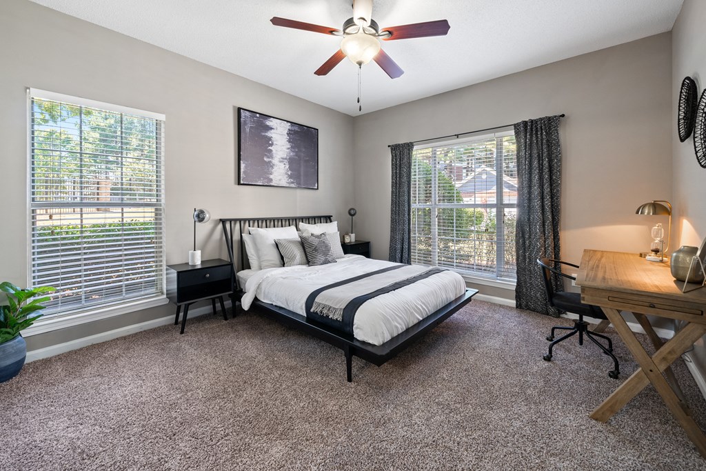 Primary bedroom with large windows located at Sugarloaf Crossings Apartments in Lawrenceville, GA 30046