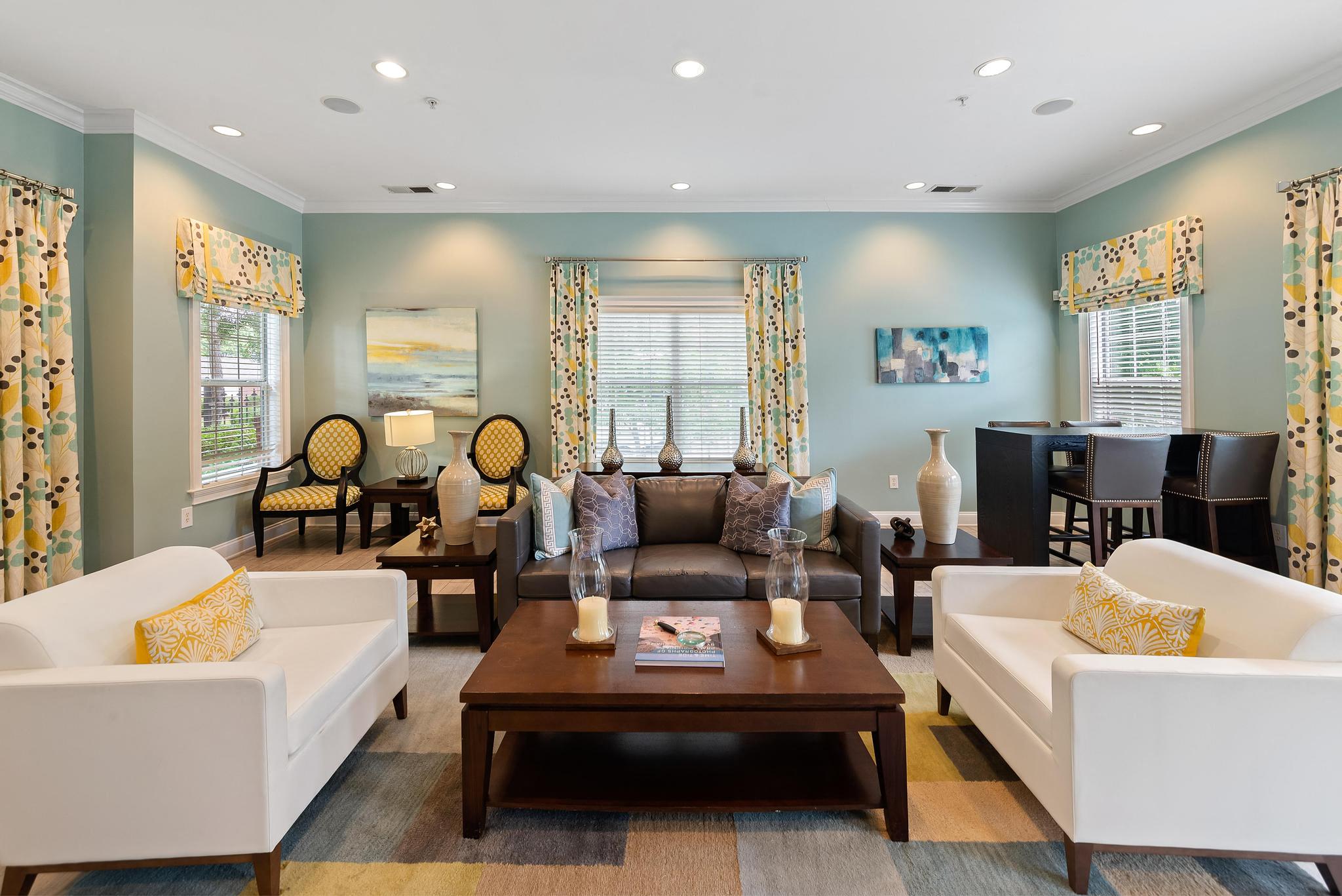 A living room with a white couch, a brown coffee table, and a painting on the wall.