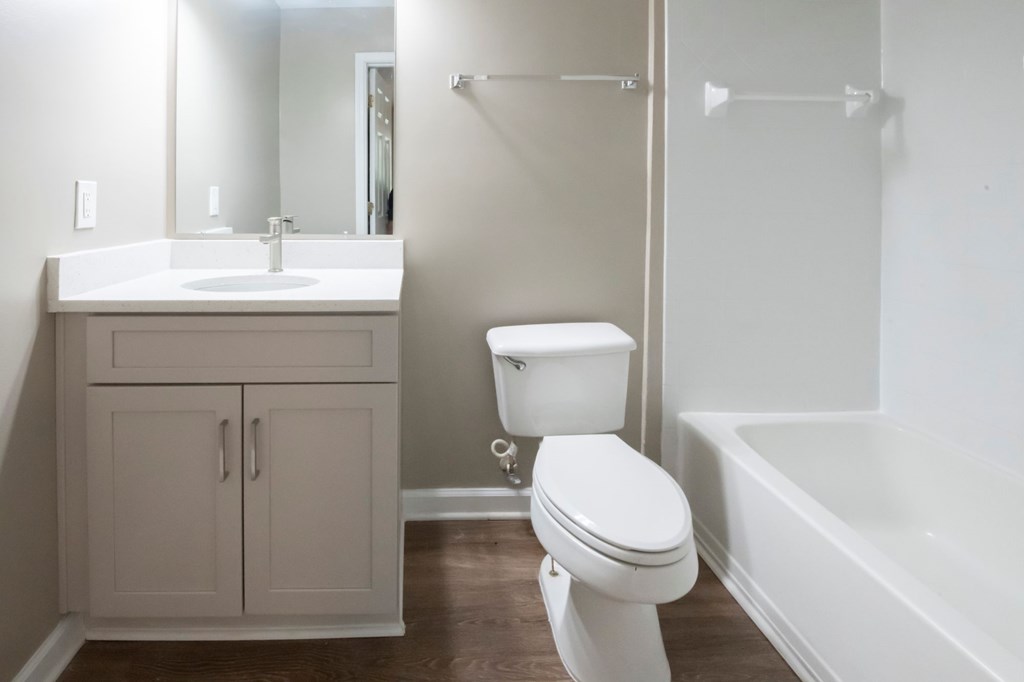 A white toilet sits next to a white sink in a bathroom.