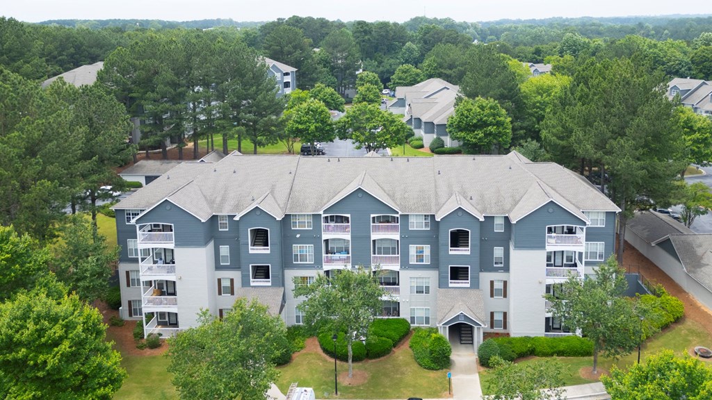 A large apartment complex surrounded by trees.